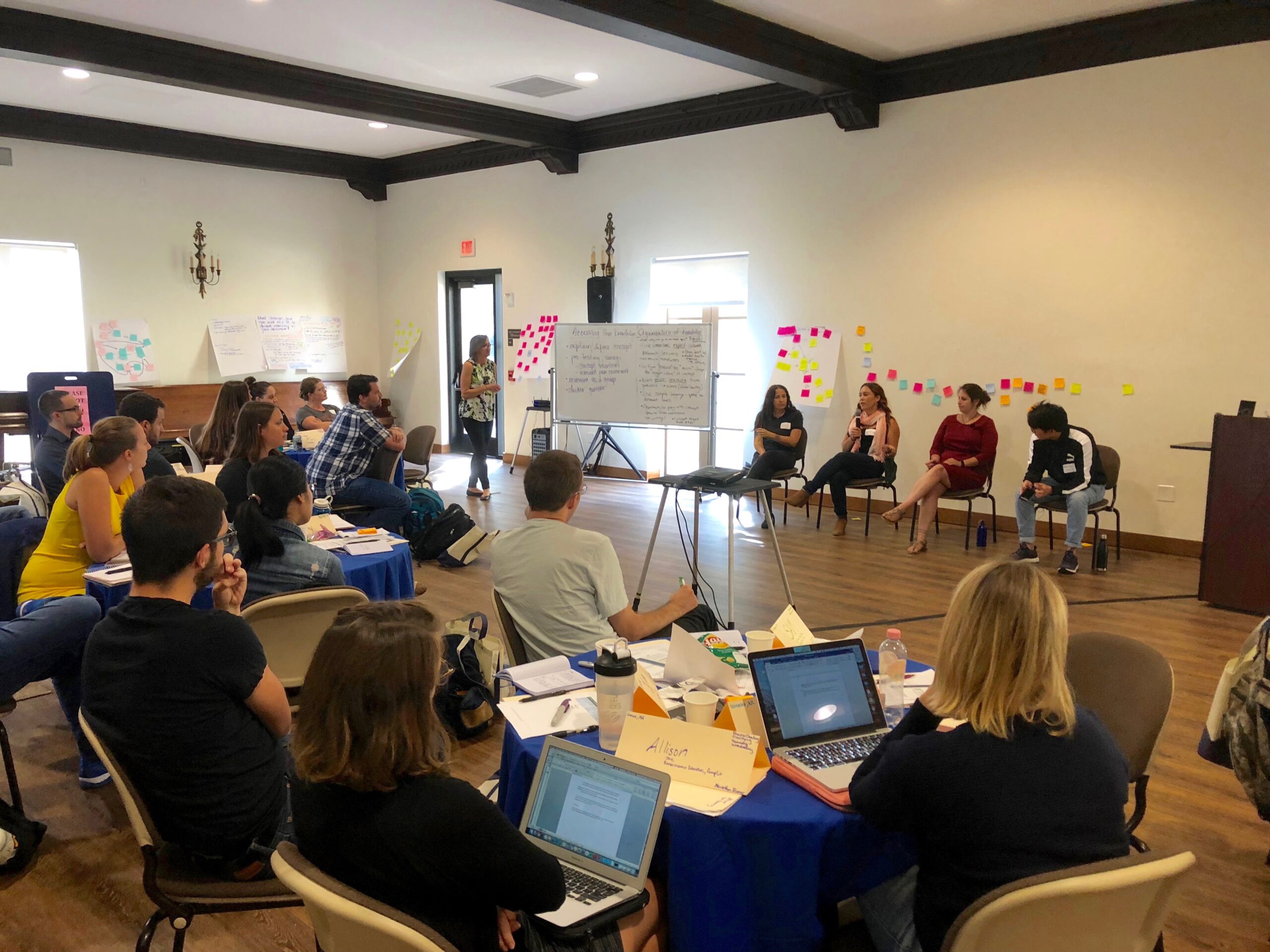 A group of attendees at a CEILS workshop listening to a 4 speaker panel.